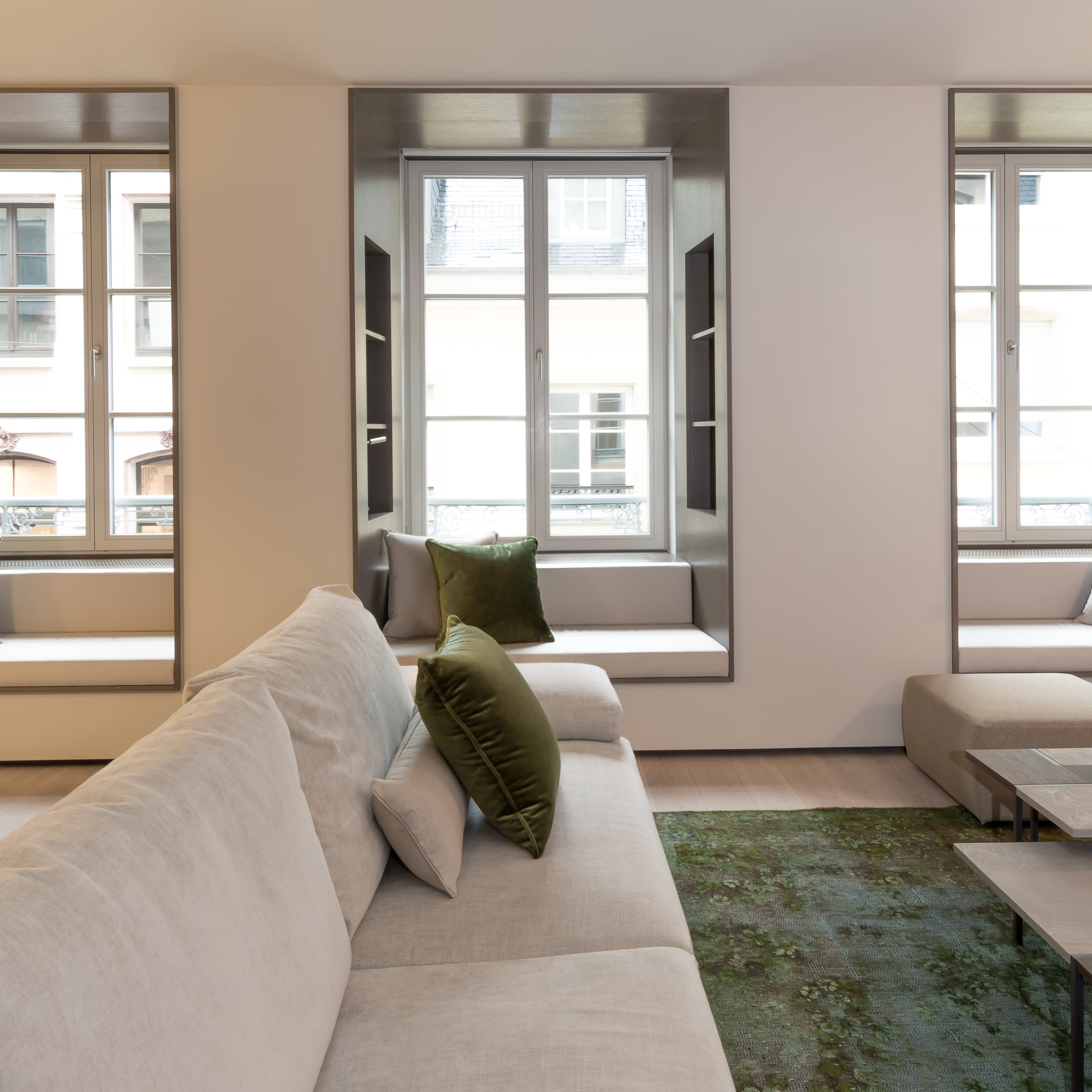 A living room with green velvet pillows at Relais Louvigny.